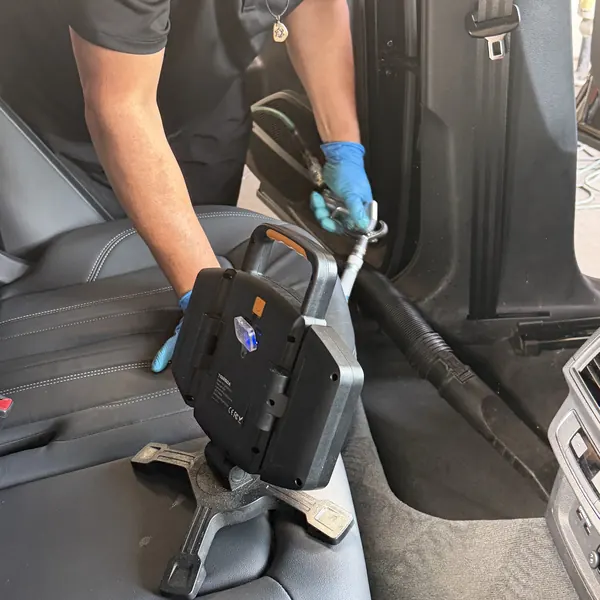 Technician vacuuming the back seat