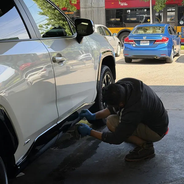 Technician scrubbing a wheel by hand